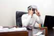 © Богдан Маліцький - person in the workplace with VR glasses plays virtual reality, the employee looks into virtual space