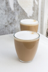 Two Glasses of coffee with cream on white background