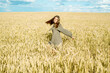 © irishasel - ears of wheat. young girl in dress shows emotion. emotionally jumps and runs on a summer field with spikelets. Hair flying in the wind, lifestyle Concept of cosmetology, harvest, farm