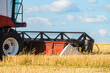 © nskyr2 - Cutter platform of reaping machine at work. Combine harvester in the field.