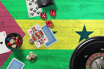 Wall Mural - Sao Tome And Principe casino theme. Aces in poker game, cards and chips on red table with national wooden flag background. Gambling and betting.