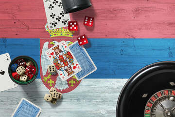 Wall Mural - Serbia casino theme. Aces in poker game, cards and chips on red table with national wooden flag background. Gambling and betting.