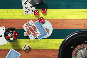 Wall Mural - Uganda casino theme. Aces in poker game, cards and chips on red table with national wooden flag background. Gambling and betting.