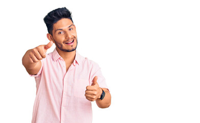 Handsome latin american young man wearing casual summer shirt approving doing positive gesture with hand, thumbs up smiling and happy for success. winner gesture.