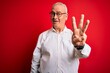 © Krakenimages.com - Middle age handsome hoary man wearing casual shirt and glasses over red background showing and pointing up with fingers number three while smiling confident and happy.