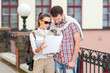 © danmorgan12 - Vacations And Traveling Ideas. Positive Caucasian Couple Traveling Around City With Camera. Looking for Destination with City Map.