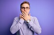 © Krakenimages.com - Young handsome redhead man wearing casual shirt and glasses over purple background shocked covering mouth with hands for mistake. Secret concept.