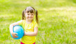 © Ermolaev Alexandr - Smiling little girl with syndrome down holds ball in a summer park. Empty space for text