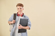 © DragonImages - Portrait of smiling high school student with laptop and backpack looking at camera