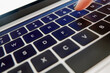 © Andréa Stuart - Closeup of laptop keyboard with finger typing