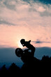 © Dmitry Yakovtsev - The silhouette of a motorcyclist at sunset. Moto rider making a stunt on his motorbike.