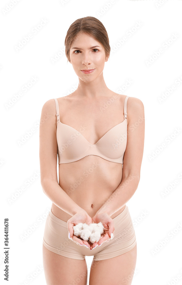 Beautiful young woman with cotton flowers on white background