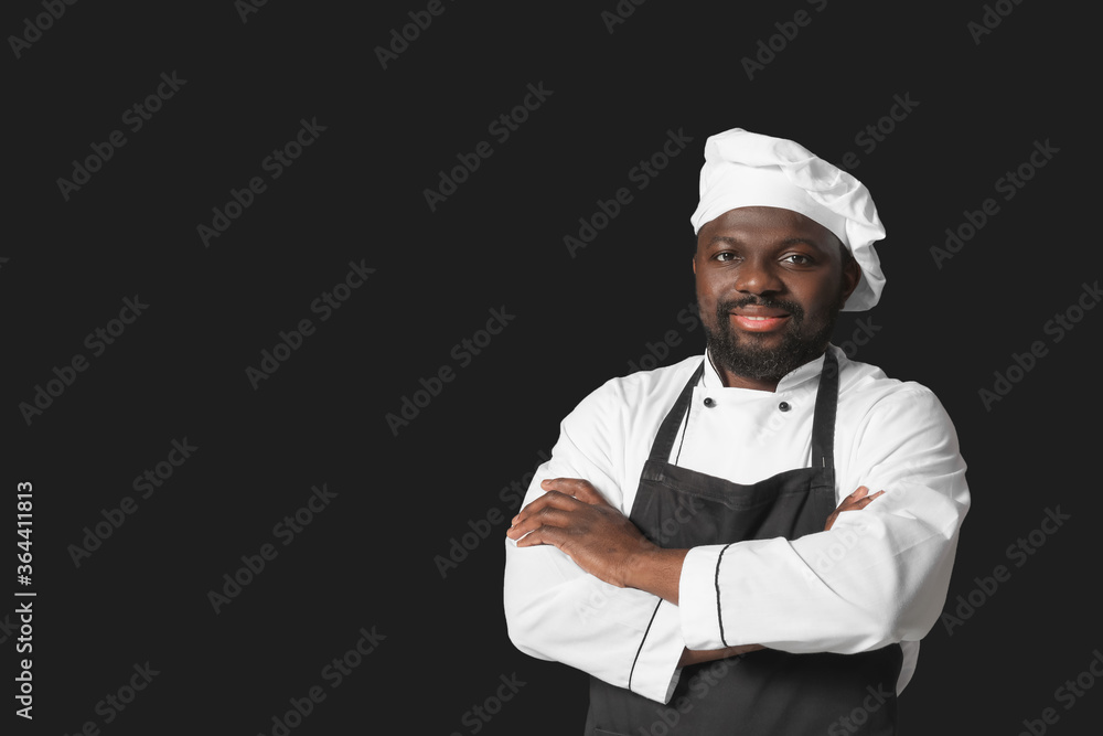 Male African-American chef on dark background