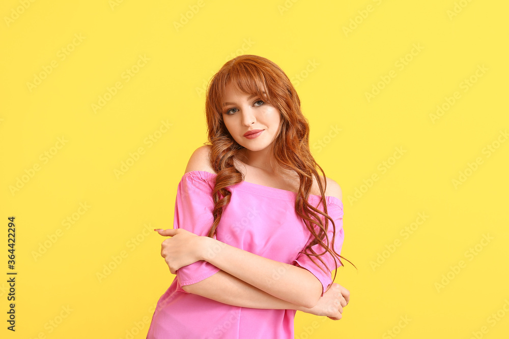 Beautiful young redhead woman on color background