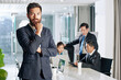 © DragonImages - Portrait of bearded handsome young entrepreneur standing at table in meeting room and looking at camera