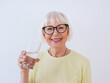 senior woman holding glass of water and drinking water. Healthy lifestyle, sport, anti age concept