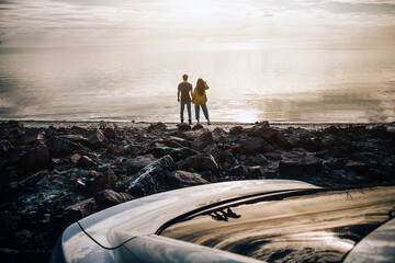 Wall Mural - Car Travel, tourism - enjoyment, relaxation in the tourism, travel, free time, rest, the concept of happiness. Silhouette of the couple near the coast