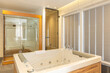 interior of luxury hotel bathroom with hydromassage bathtub and shower cabin