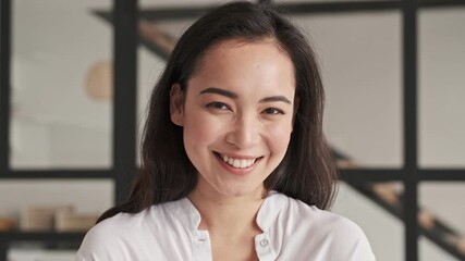 Wall Mural - Smiling elegant pretty asian woman becoming happy and looking at the camera at home