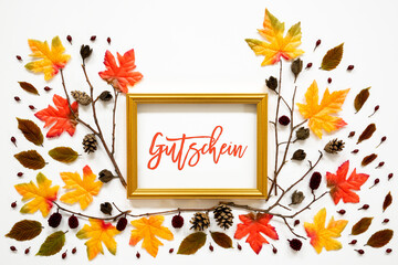 Wall Mural - golden frame with german text gutschein means voucher. beautiful, colorful autumn leaf decoration wi