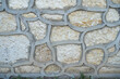 A wall made of natural stones and wood of different sizes and shapes, a fortress made of wood on a Foundation of stone.