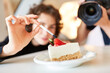 Stylist with brush and cake during food styling