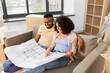 © Syda Productions - mortgage, people and real estate concept - happy african american couple with boxes and blueprint moving to new home