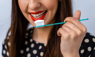 Canvas Print - Portrait of beautiful young woman with toothbrush in hands. Healthy white teeth. Dental concept.