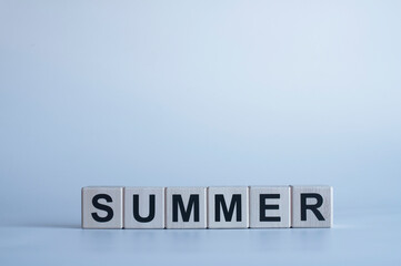 Summer. Black letters on wooden cubes. On a blue background