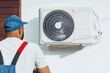 © fotofabrika - Repairman in uniform installing the outside unit of air conditioner