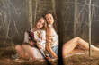 Beautiful girls posing together on forest background