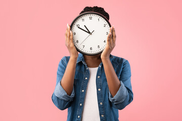 African Girl Holding Clock In Front Of Face, Pink Background
