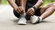 Closeup Of Black Sportsman Tying His Shoelaces Before Training