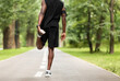 © Prostock-studio - Cropped of black guy exercising at park, stretching legs