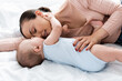 © LIGHTFIELD STUDIOS - mother with closed eyes lying on bed with baby boy