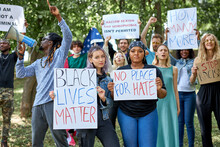 Stop Racism All Over The World. Multiethnic Group Of People With Posters Look At Camera. Black Lives Matter Concept