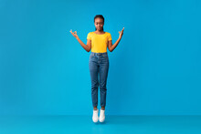 African American Millennial Girl Meditating In Mid-Air Over Blue Background