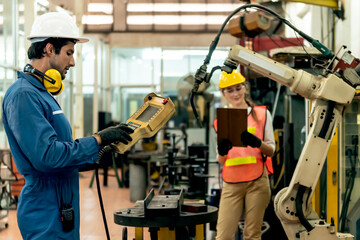 Blurred soft images of Caucasian, Female engineer and male technician working together checking the working conditions Of industrial machinery or Robotic hands, to industry concept.