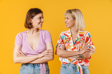 Sticker - Portrait of two cheerful lovely girlfriends standing