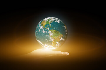Canvas Print - environment concept. earth with light in human hand on black background. elements of this image furn