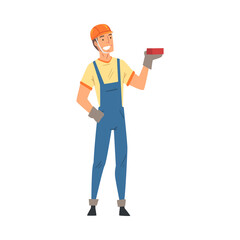 Wall Mural - Male Builder, Construction Worker Character in Blue Overalls Standing with Brick Vector Illustration on White Background