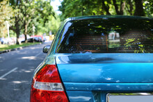 Back Window Of Blue Car Parked On The Street In Summer Sunny Day, Rear View. Mock-up For Sticker Or Decals