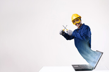 Repair work online. A man in a blue uniform and work helmet with screwdrivers in his hands comes out of the laptop screen. Repair consultations. Copy space