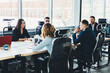 © BullRun - Business meeting of young male and female entrepreneurs dressed in formal wear in modern office interior.Employees sitting at meeting table during conference with proud ceo in finance company
