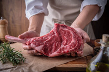 Butcher Serving Fresh Tomahawk Steak Meat To Customer