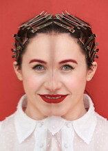 Happy Young Female Model With Creative Makeup With Red Eyebrows And Lips And Unusual Hairdo With Many Metal Hair Clips On Red Background
