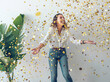 © PHILIPPE DEGROOTE/ADDICTIVE STOCK - Beautiful young woman in stylish outfit laughing and looking up while standing under?falling golden confetti against white wall