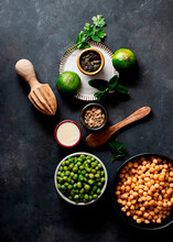 From Above Chickpeas And Green Peas Placed On A Bowl Near Crackers On Dark Background