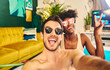 © Victor Bordera/ADDICTIVE STOCK - Cheerful multiracial couple wearing sunglasses sitting in inflatable pool and taking selfie while enjoying weekend