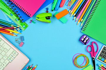 Wall Mural - School supplies frame. Top down view over a blue paper background with copy space. Back to school concept.